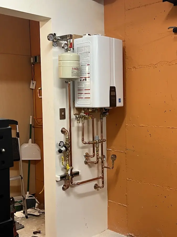 Plumbing technician inspecting water heater connections in East Hartford